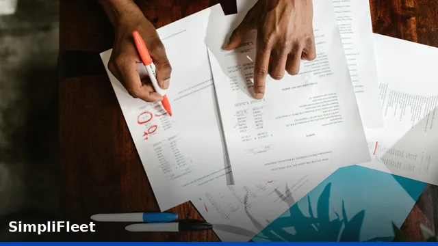 Corporate accountant analyzing fleet vehicle specifications and tax return records on a screen.